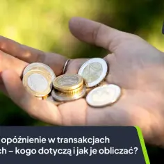 Dłoń z monetami, symbolizująca odsetki za opóźnienie w transakcjach handlowych.