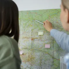 Kto to spedytor? Dwie kobiety planują trasę na mapie, wskazując drogę.