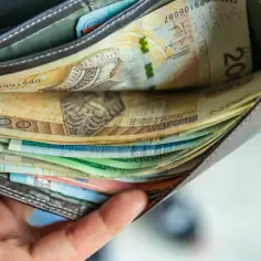 Portfel pełen polskich banknotów, w tym 200 zł. Widać różne nominały i kolory papierowych pieniędzy.