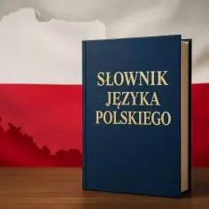 Słownik języka polskiego stoi na drewnianym stole. W tle flaga Polski z konturem kraju. Wiedza o języku polskim, sprzed czy z przed, jest kluczem do zrozumienia kultury.