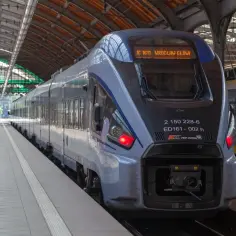 Nowoczesny pociąg PKP Intercity na peronie. Konduktor czeka na pasażerów, którzy wysiadają z pociągu.