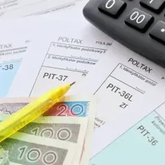 Formularze PIT, kalkulator, polskie banknoty i żółty długopis – wszystko gotowe do rozliczenia podatku i uzyskania zwrotu podatku.