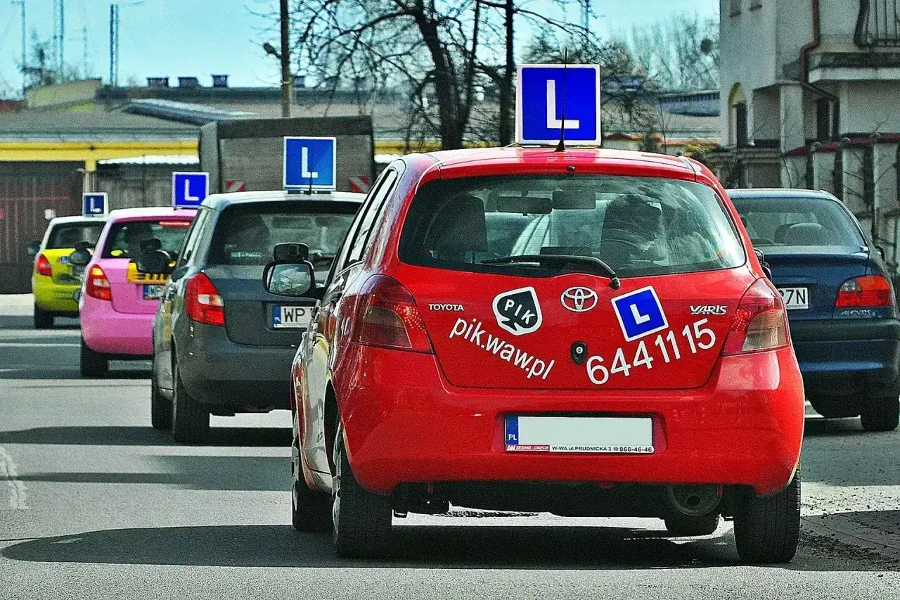 Czerwony samochód nauki jazdy z literą 