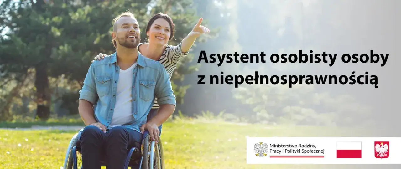 Uśmiechnięty mężczyzna na wózku inwalidzkim i jego asystentka osoby niepełnosprawnej wskazują palcem w dal.